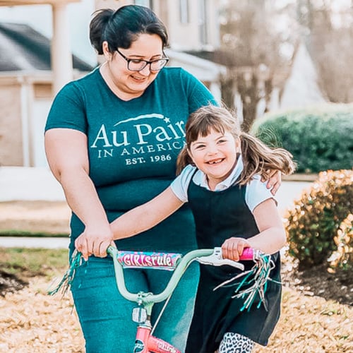 Ein Kind und eine Person mit Au Pair in America T-Shirt