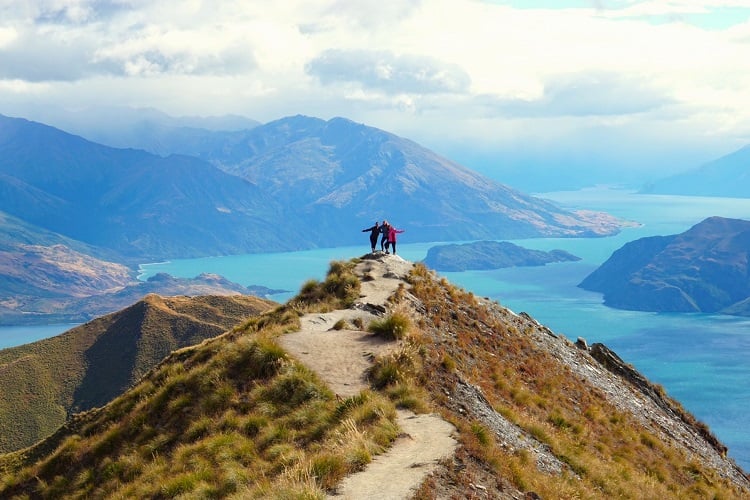 Personen stehen auf dem Roys Peak in Neuseeland