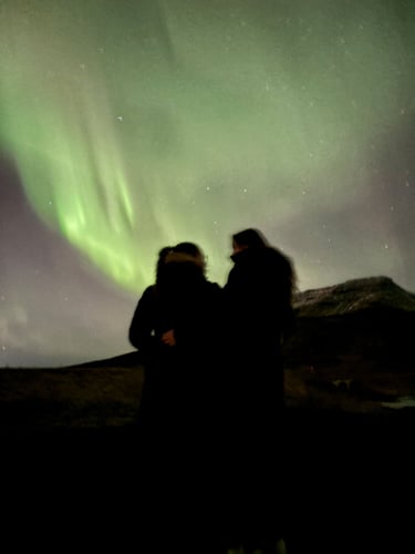 AIFS Au Pair in Island schaut mit einer Freundin Nordlichter an