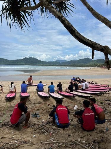 Eine Gruppe am Strand während des Surfkurses beim Surfcamp in Red Island, Bali mit AIFS