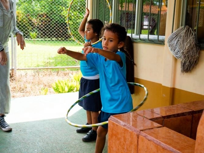 Kinder mit Hulahoop reifen beim Freiwilligenprojekt Sports Coaching in Costa Rica mit AIFS
