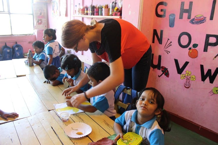 Person mit Schülerinnen und Schülern beim Freiwilligenprojekt in Sri Lanka
